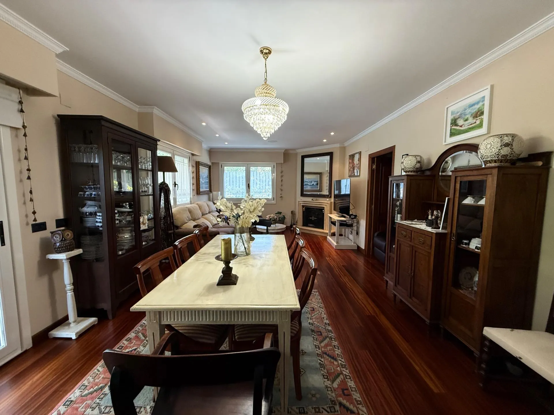 Salón comedor con araña de cristal y parquet iroko